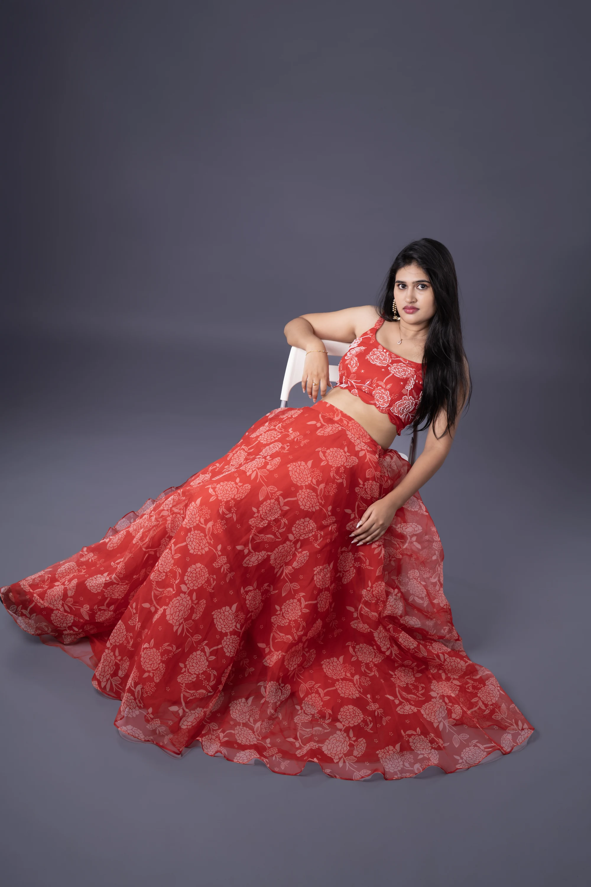 Fashion portrait in a red gown with a seated pose