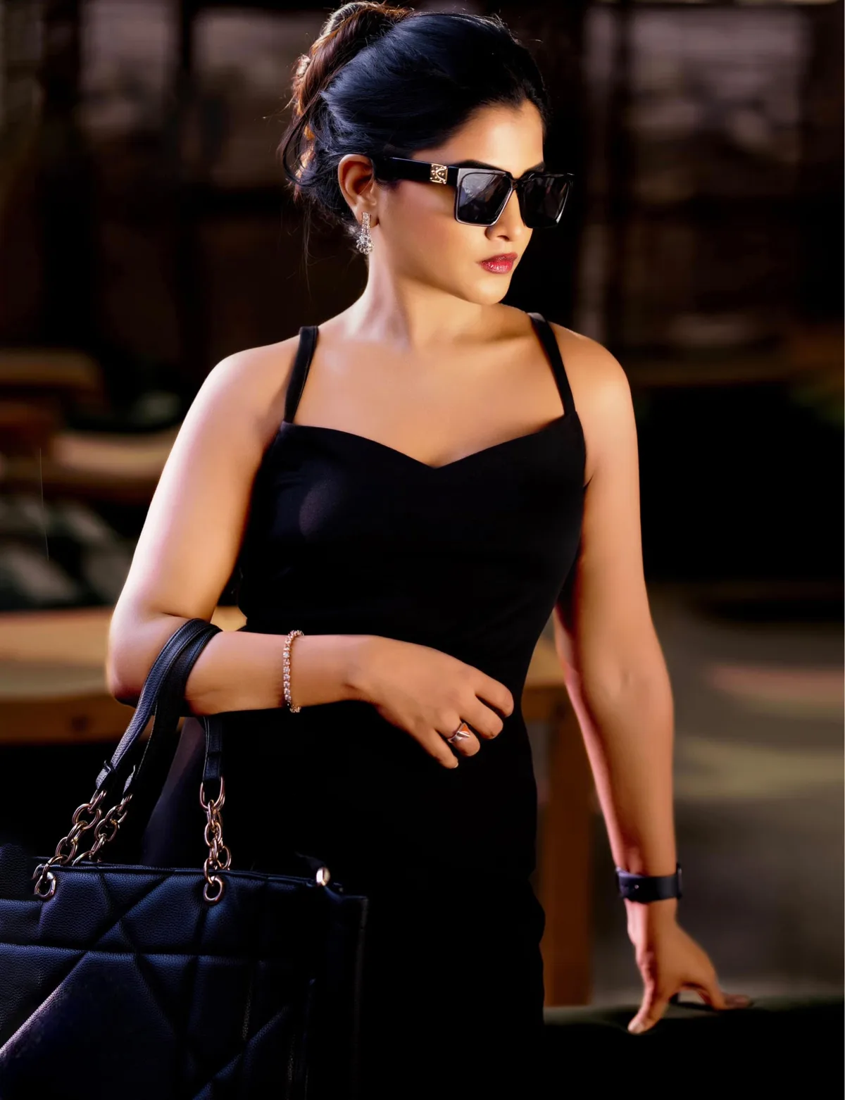 Outdoor portrait in a black dress with sunglasses and a handbag