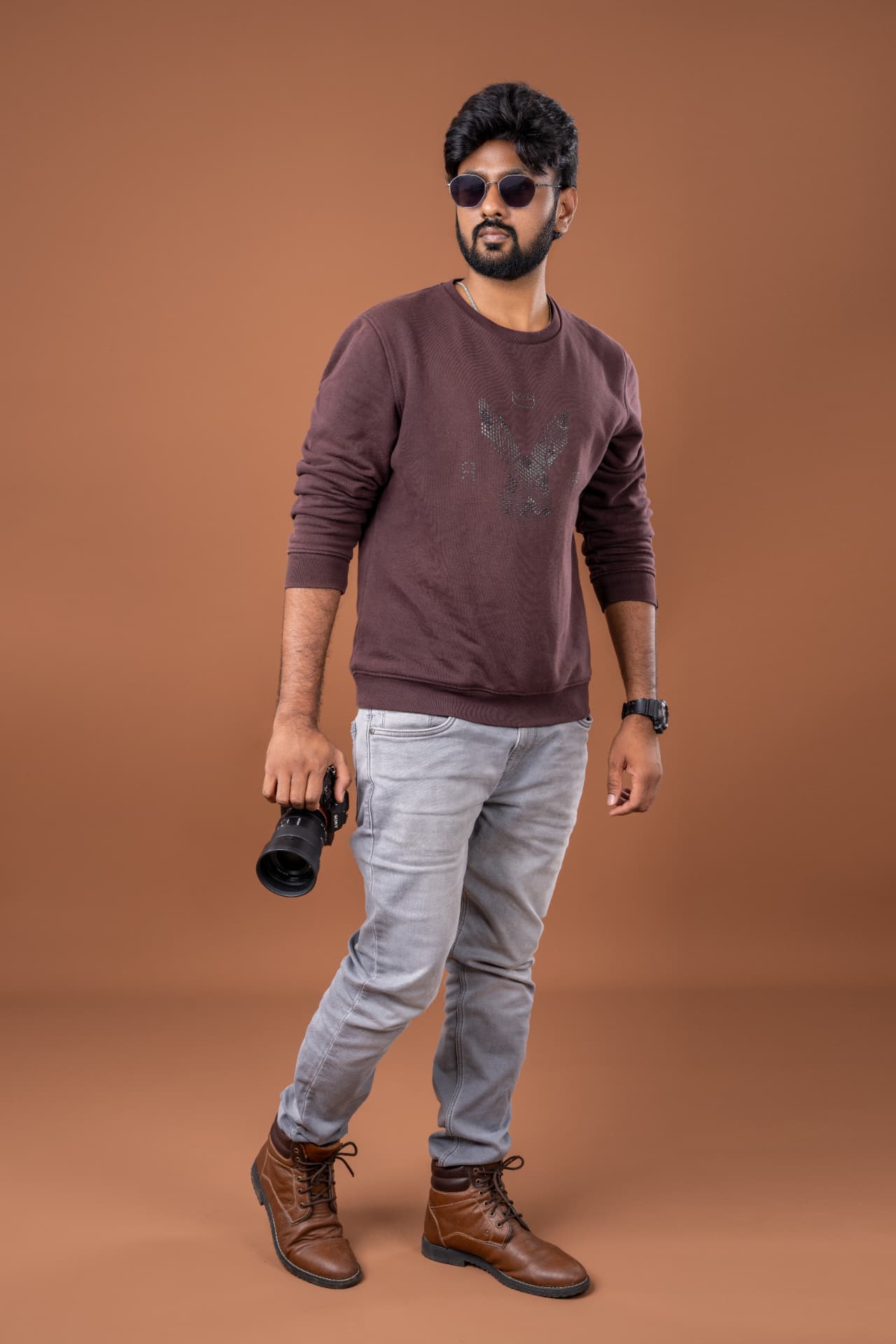Narasimha, founder of Lens Chronicle Photography, holding his camera in the studio